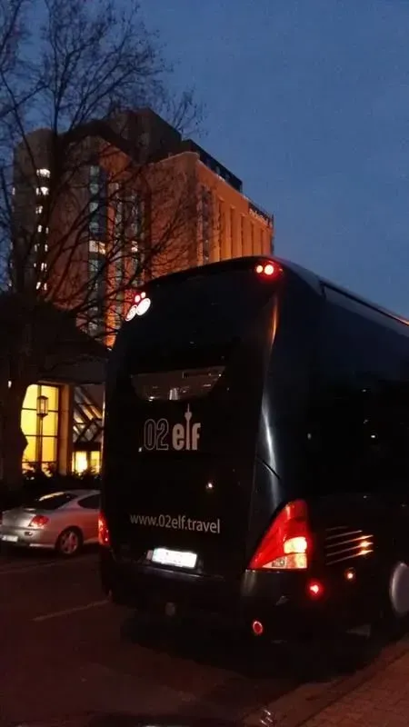 Ein schwarzer Elfenbus steht vor einem Gebäude, 02elf Travel GmbH & Co KG