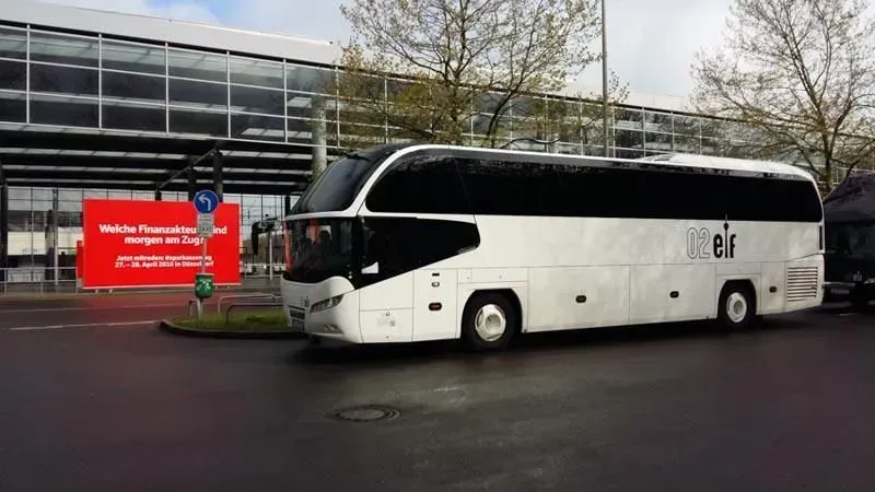 Ein weiß-schwarzer Bus parkt vor einem Gebäude.