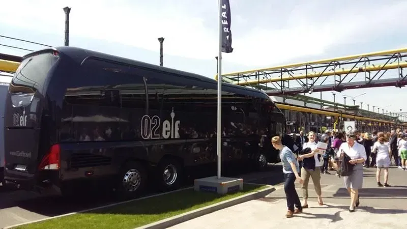Ein großer schwarzer Bus mit dem Wort „Elf“ an der Seite steht auf einem Parkplatz.