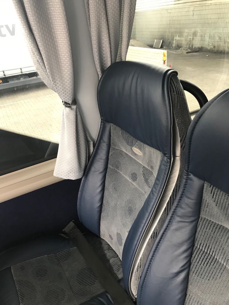 Bussitz am Fenster mit grauen Vorhängen und schwarz-grauer Polsterung