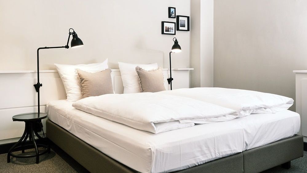 ein Doppelbett steht vor einer weißen Wand