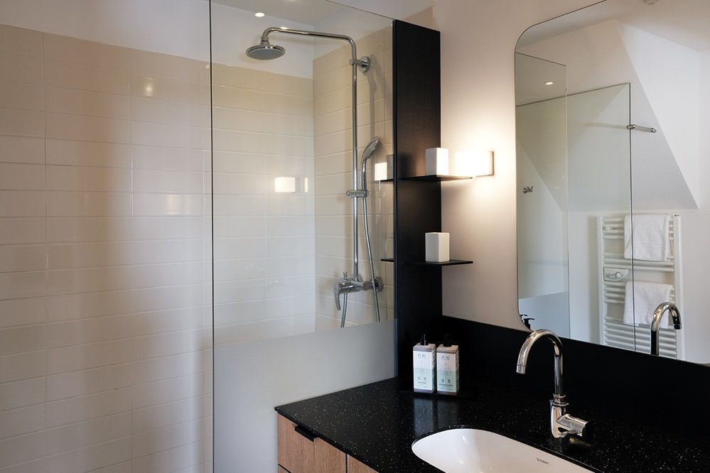 Ein Badezimmer mit Waschbecken und ebenerdiger Dusche