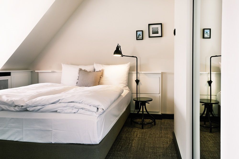 Ein Doppelbett steht unter einer Dachschrägen