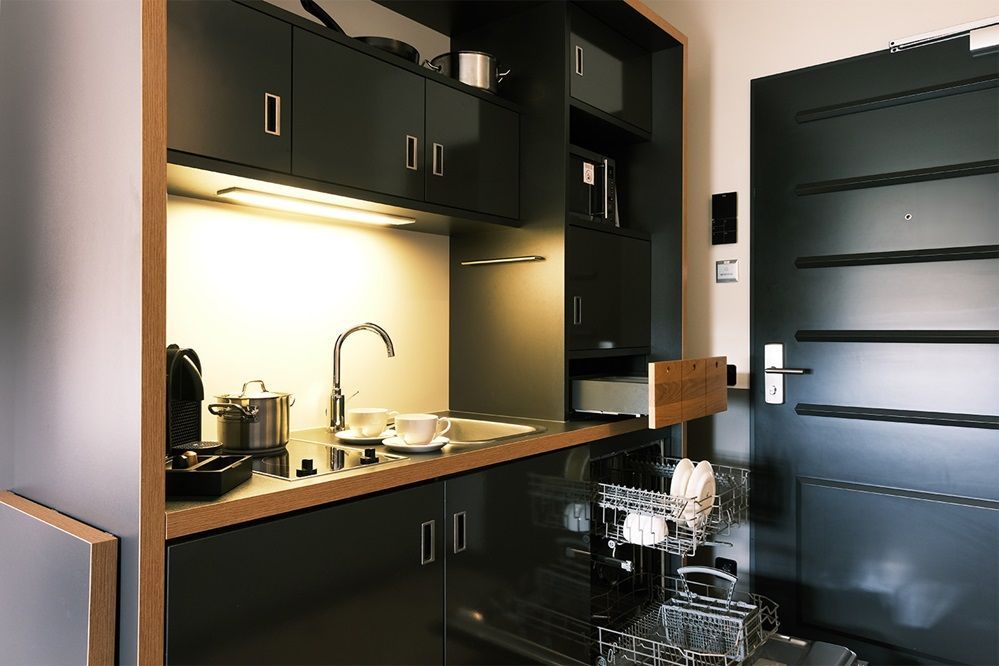 Eine Küche mit schwarzen Schränken und einem Geschirrspüler