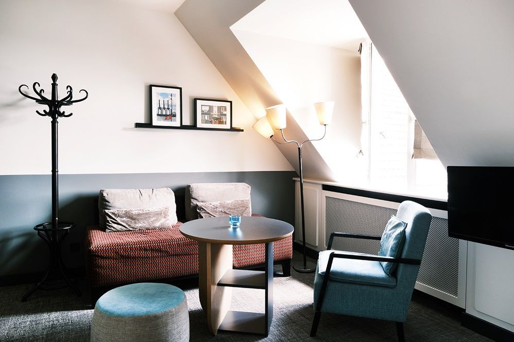 Ein Wohnzimmer mit einer Couch, einem Sessel und einem Tisch