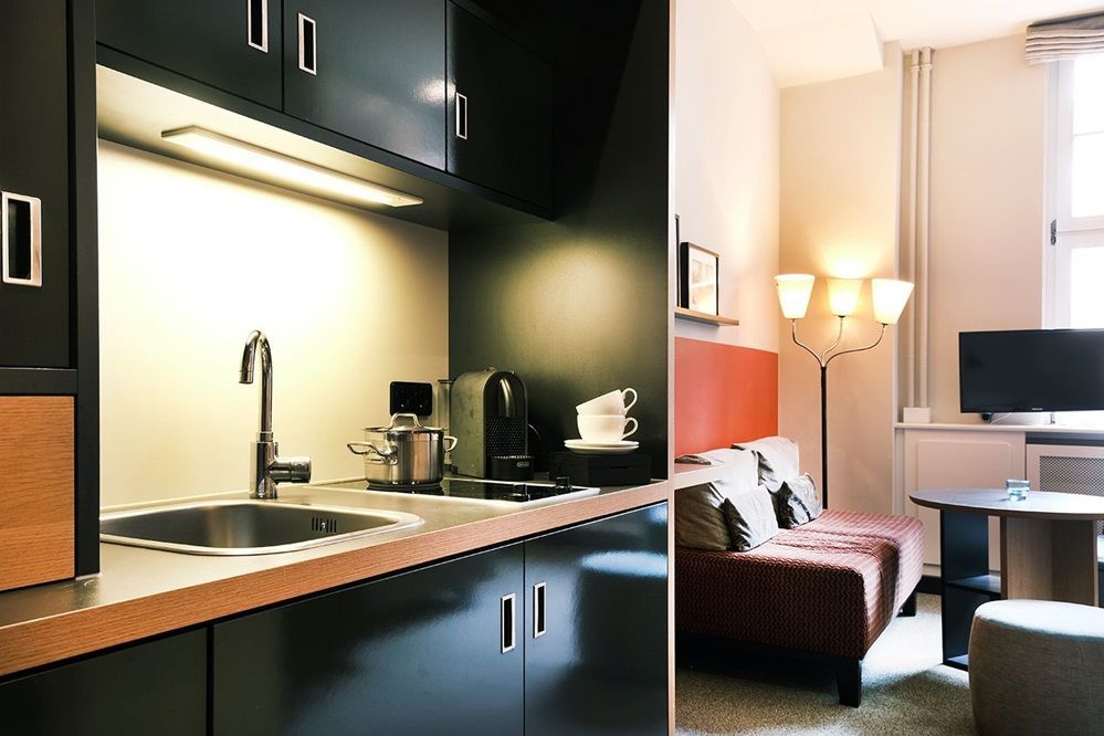 Eine Küche mit Spüle und ein Wohnzimmer mit Couch