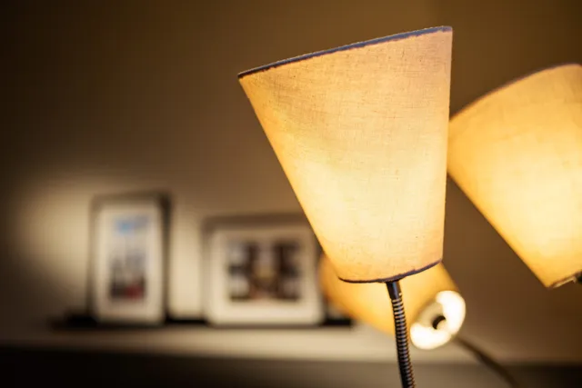 Ein paar Lampen stehen auf einem Regal neben einem Regal mit Bildern darauf.