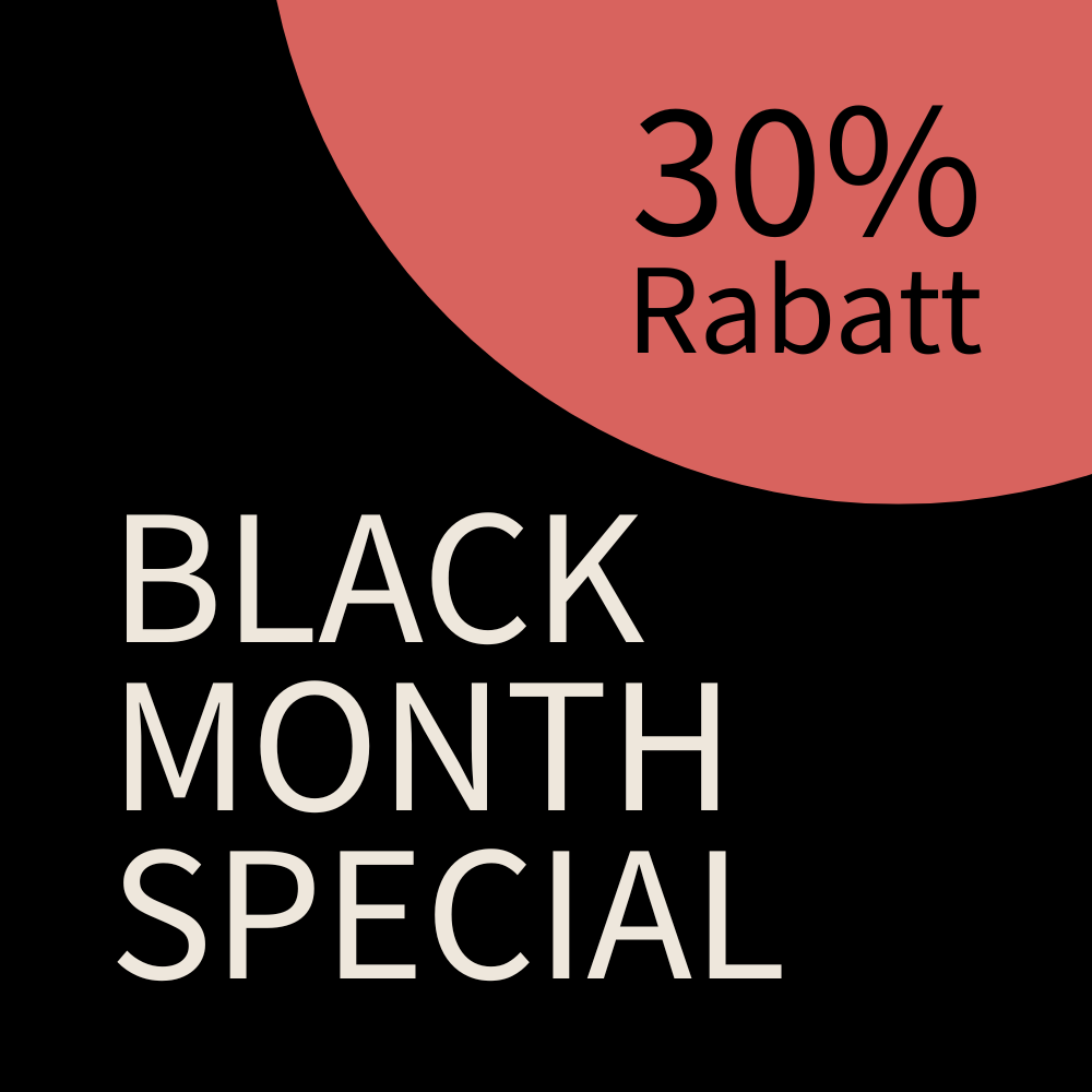 Eine Frau sitzt an einem Schreibtisch vor einem Fenster und arbeitet am Laptop. Hinter ihr steht ein großer Strauß Blumen.