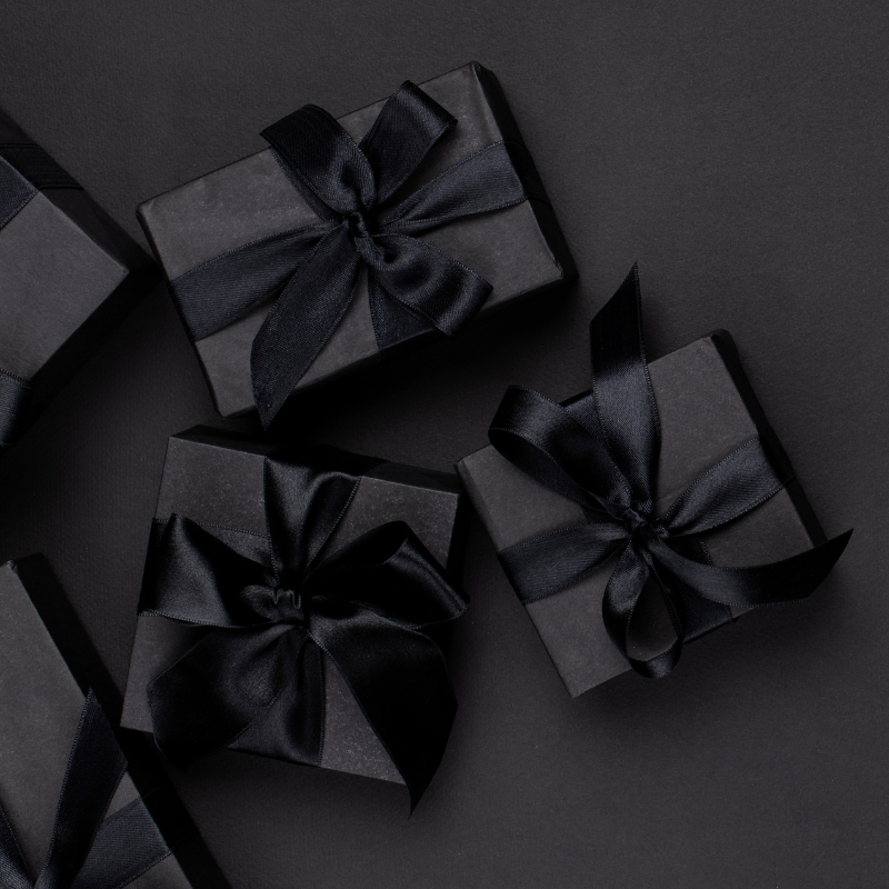 schwarze Geschenke vor schlichtem schwarzen Hintergrund