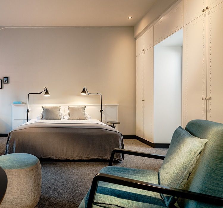 Ein Schlafzimmer mit einem großen Bett und einem Sessel