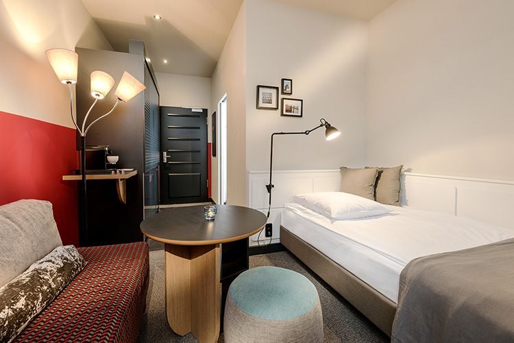 Ein Hotelzimmer mit Bett, Couch, Tisch und Lampe.