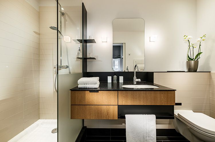 ein Badezimmer mit Waschbecken, Spiegel, Dusche und WC