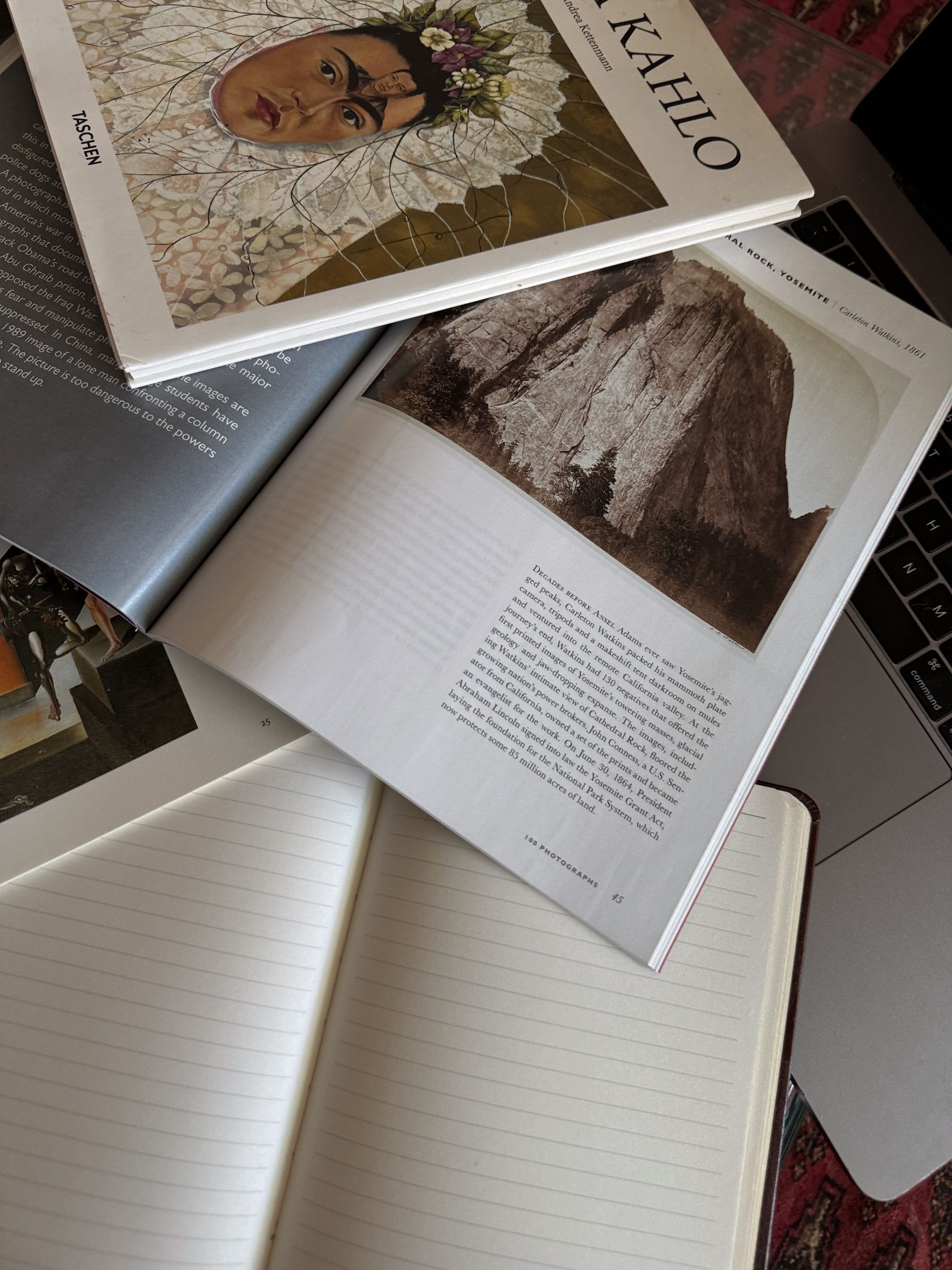 Libro sobre Frida Kahlo abierto con arte y cuaderno.