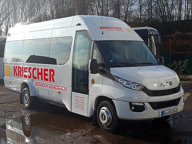 Ein weißer Lieferwagen mit roter Schrift an der Seite steht auf einem Parkplatz.