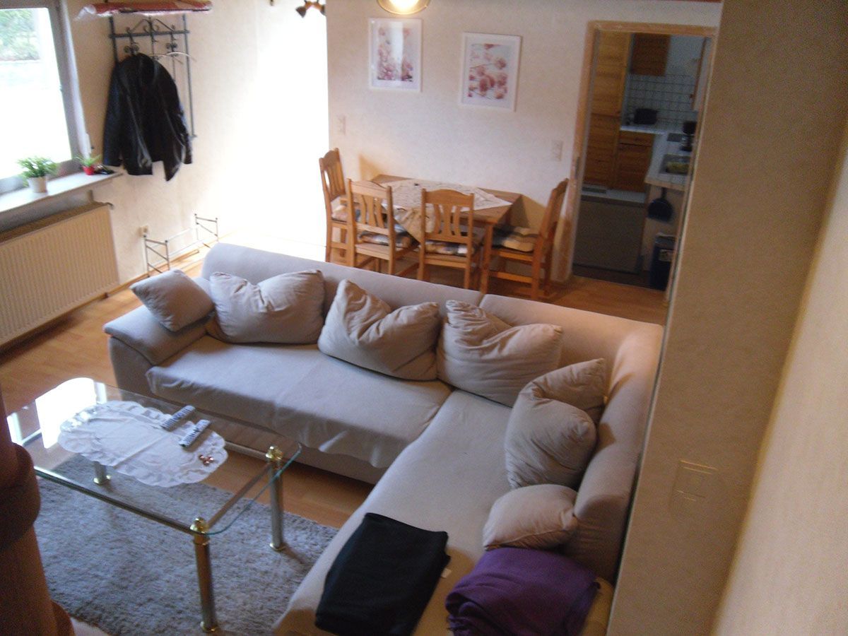 Ein Wohnzimmer mit einer Sofagarnitur und einem Couchtisch aus Glas