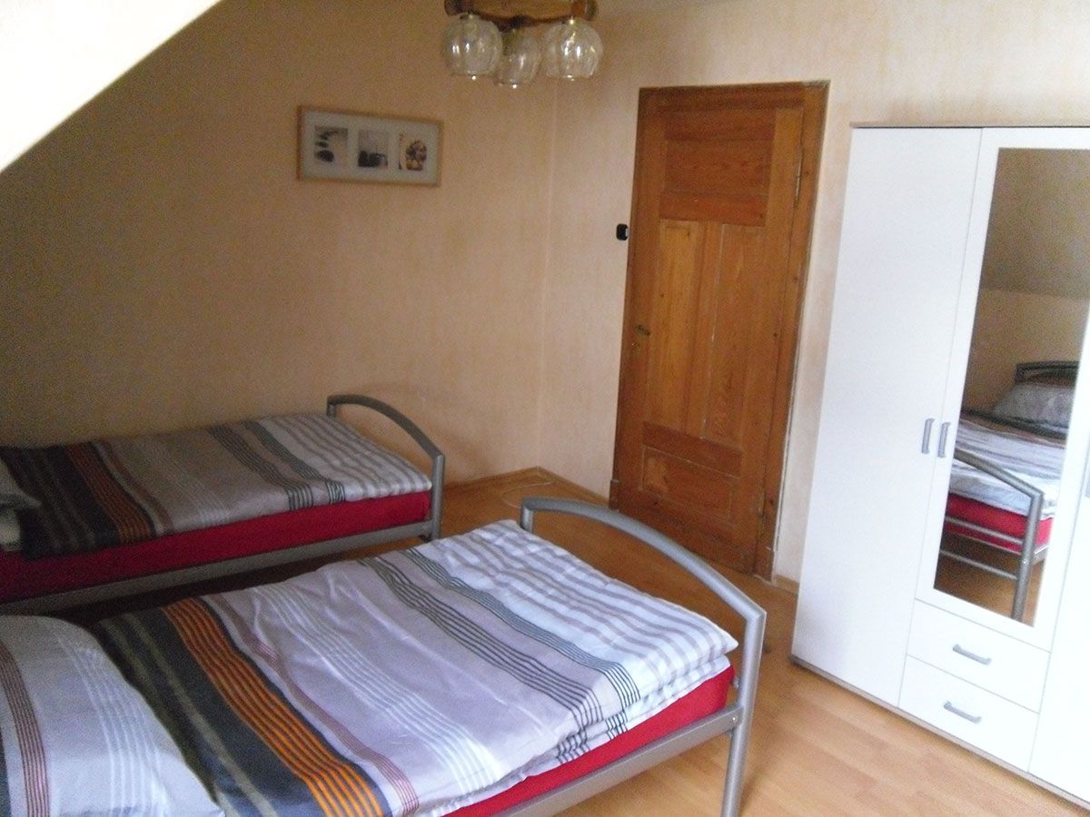 Ein Schlafzimmer mit zwei Betten und einem weißen Kleiderschrank