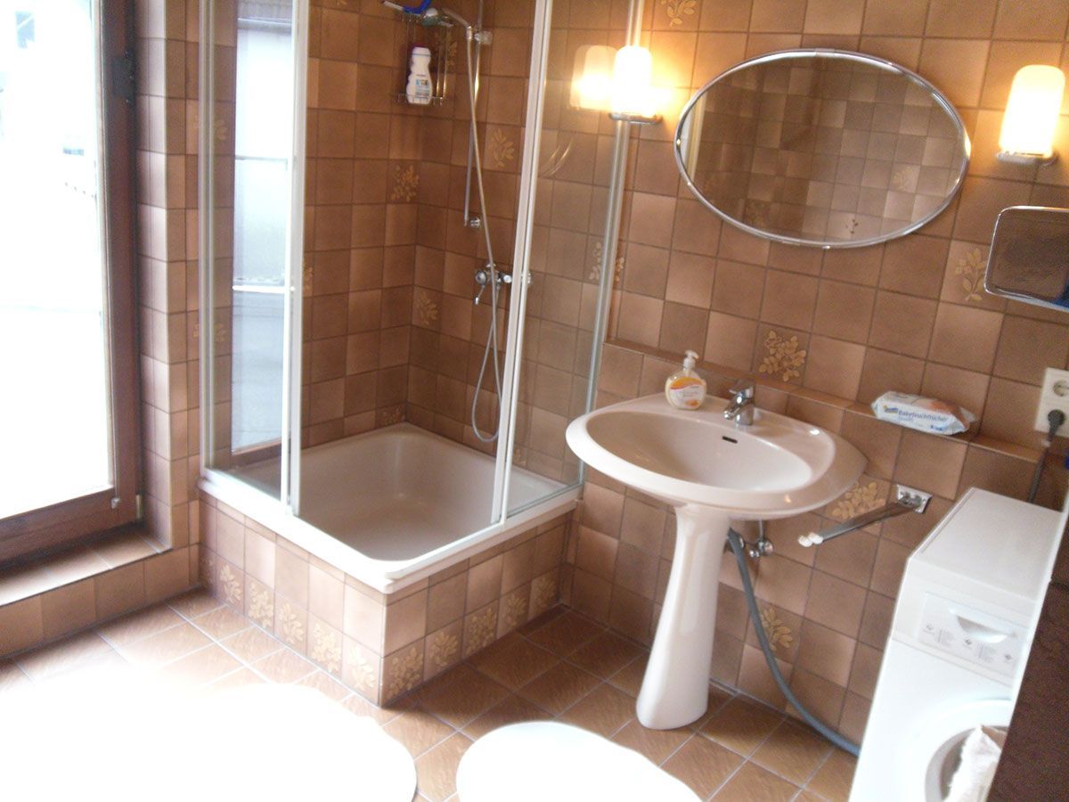 Ein Badezimmer mit Waschbecken, Toilette, Dusche und Spiegel