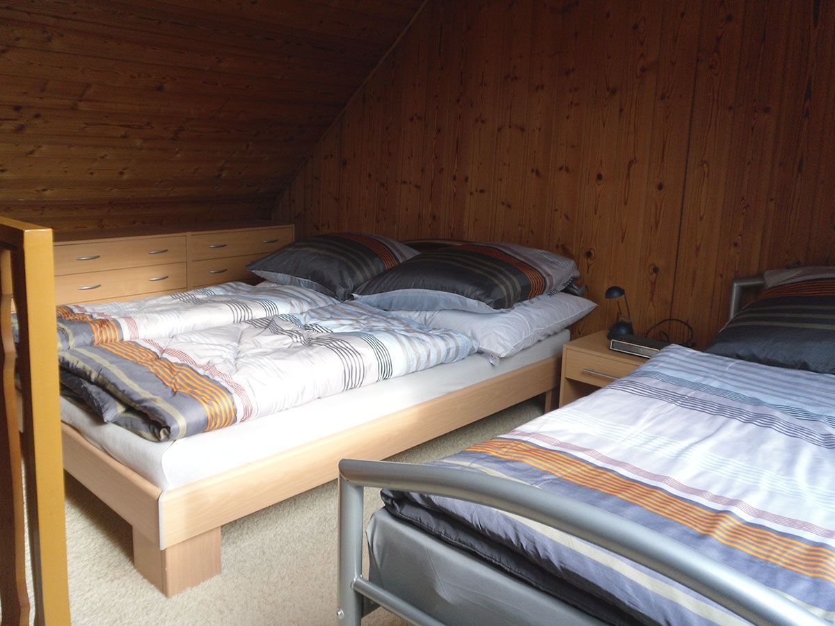 Zwei Betten in einem Schlafzimmer mit Holzwänden