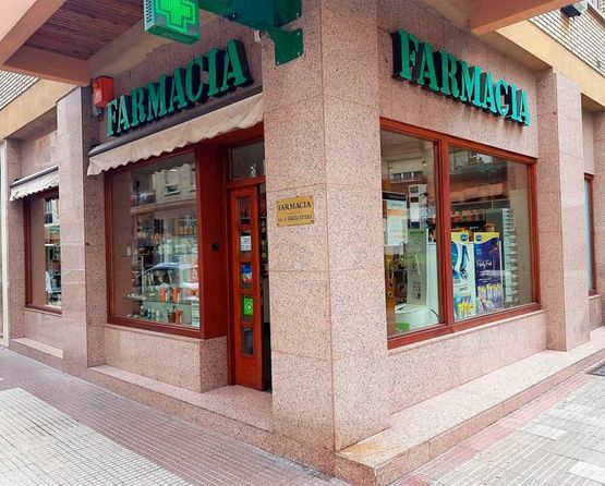 Una farmacia con un jarrón de flores en el mostrador.