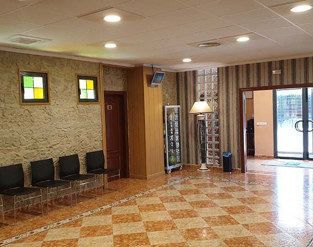 Una habitación grande con sillas y una lámpara.