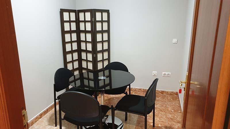 Una habitación con una mesa y sillas y un biombo.