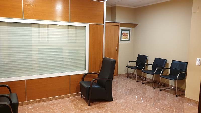 Una sala de espera con sillas y una ventana.