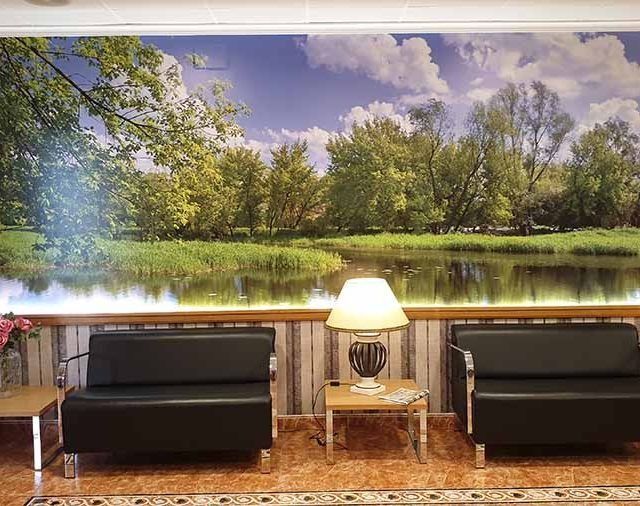 Una sala de espera con una imagen de un lago en la pared.