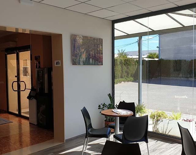 Una habitación con una mesa y sillas frente a una ventana.
