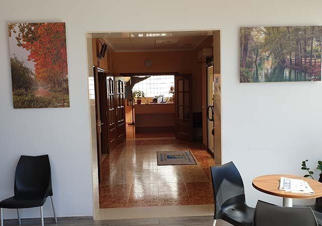 Una habitación con una mesa y sillas y cuadros en la pared.