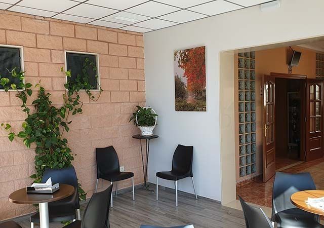 Una habitación con mesas y sillas y un cuadro en la pared.