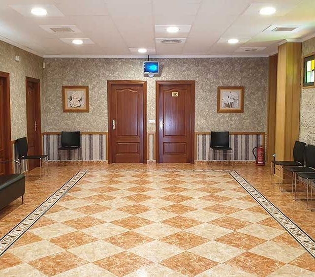 Una habitación grande con suelo a cuadros y sillas.