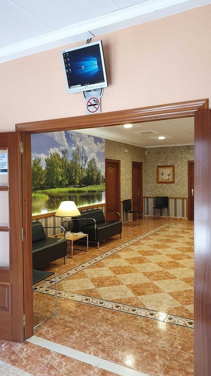 Una habitación con un sofá y un televisor en la pared.