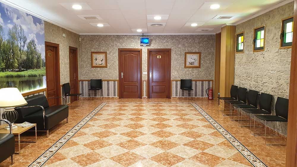 Un largo pasillo con sillas y un sofá en un edificio.