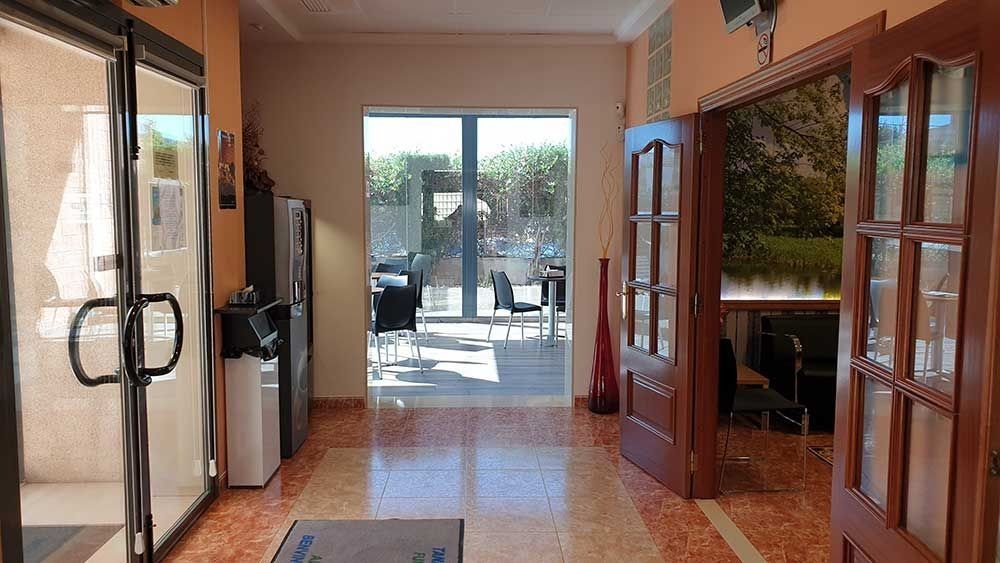 Un pasillo con muchas ventanas y puertas.