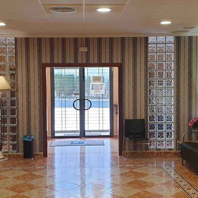 Una habitación grande con una puerta corrediza de vidrio y un piso cuadriculado.