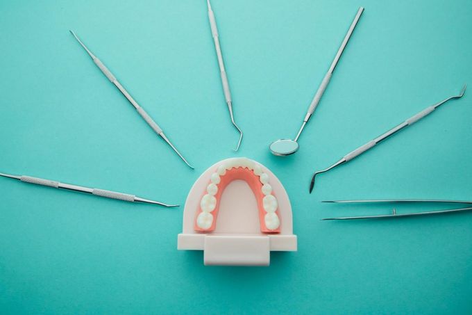 Sala de exploración dental con sillón, luz cenital y bandeja de instrumental.