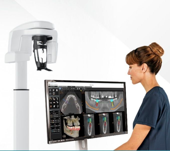 Paciente sometiéndose a una radiografía dental mientras un profesional le ajusta el mentón en una consulta dental.