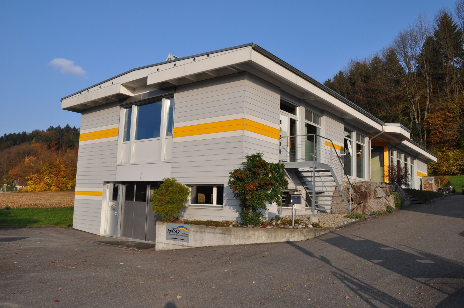 Ein rotes Auto wird in einer Lackierkabine lackiert.