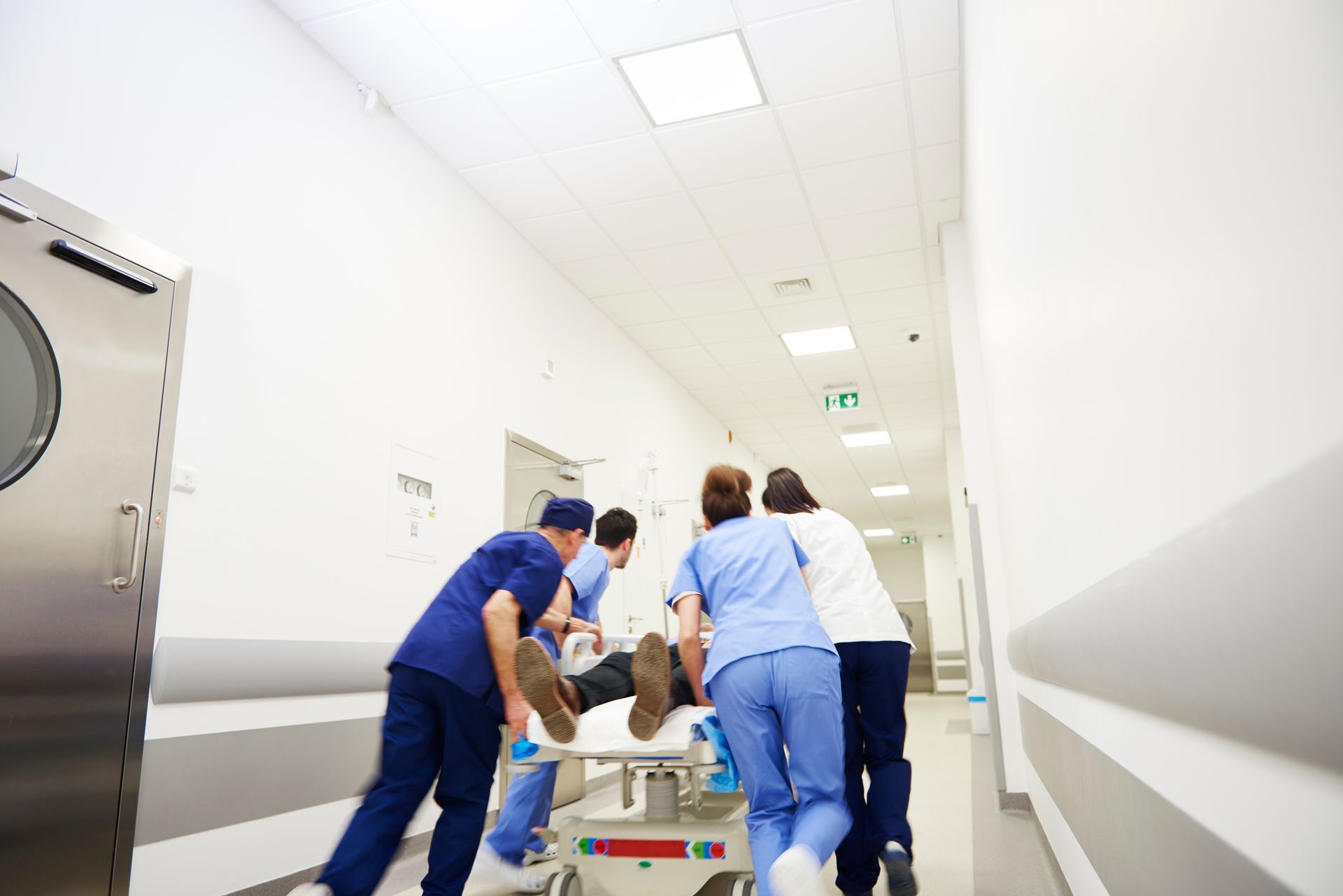 Des membres du personnel médical transportent un patient sur une civière dans le couloir lumineux d'un hôpital.