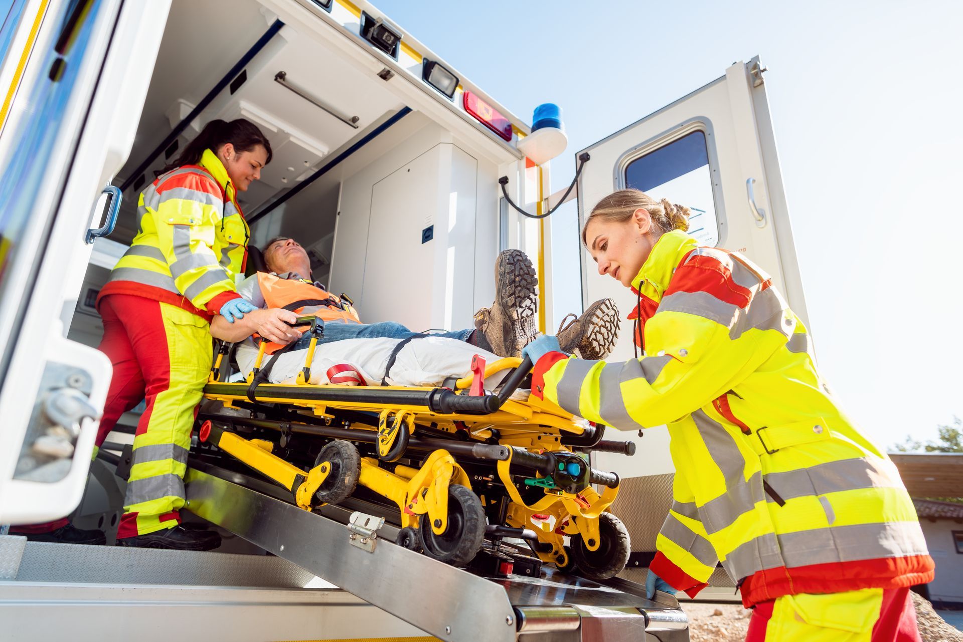 Des ambulanciers chargent un patient sur une civière dans une ambulance après une urgence médicale.