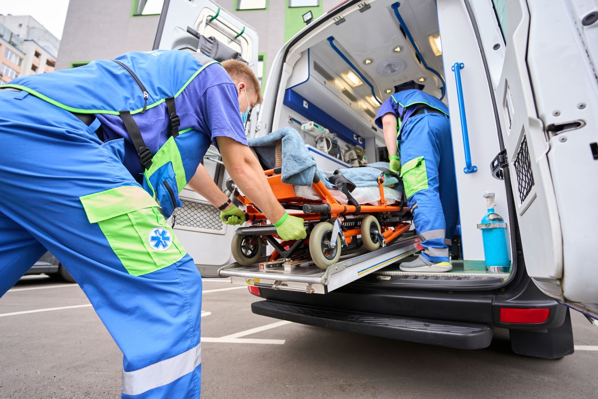 Brancard chargé dans une ambulance par deux ambulanciers lors d’une intervention médicale.