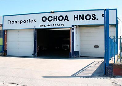 Un edificio blanco con un cartel que dice transportes ochoa hnos