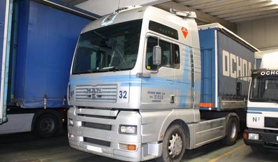 Un camión con el número 32 en el costado está estacionado en un almacén.