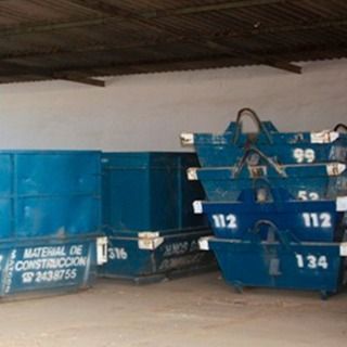 Una pila de contenedores de basura azules con los números 112 y 134 en ellos