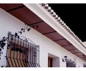 Un edificio blanco con balcón y techo.