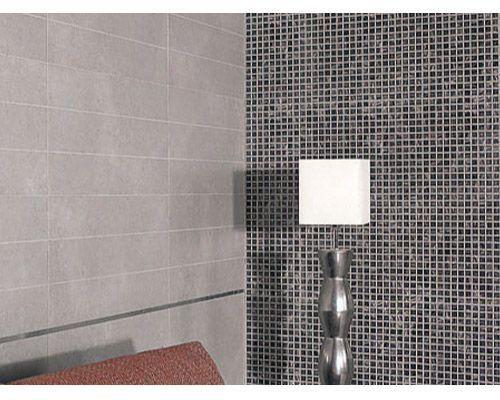 Una lámpara está situada delante de una pared con azulejos.