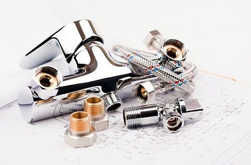 Un montón de piezas de plomería están colocadas sobre un trozo de papel.