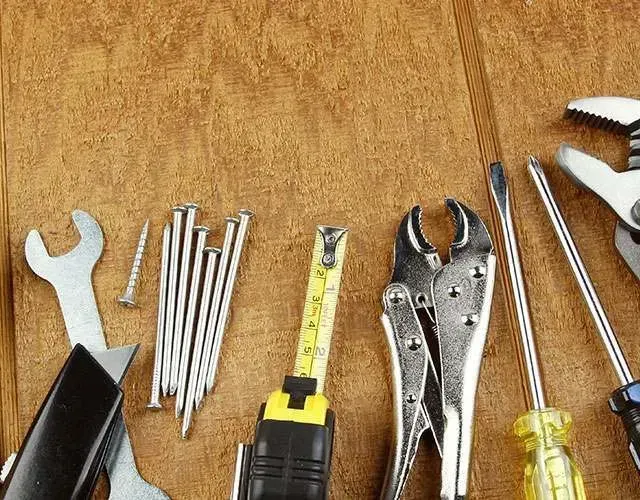 Un montón de herramientas están sobre una mesa de madera.