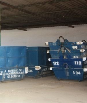 Un montón de contenedores de basura azules están apilados uno encima del otro.
