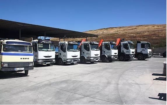 Una fila de camiones están estacionados en un estacionamiento.